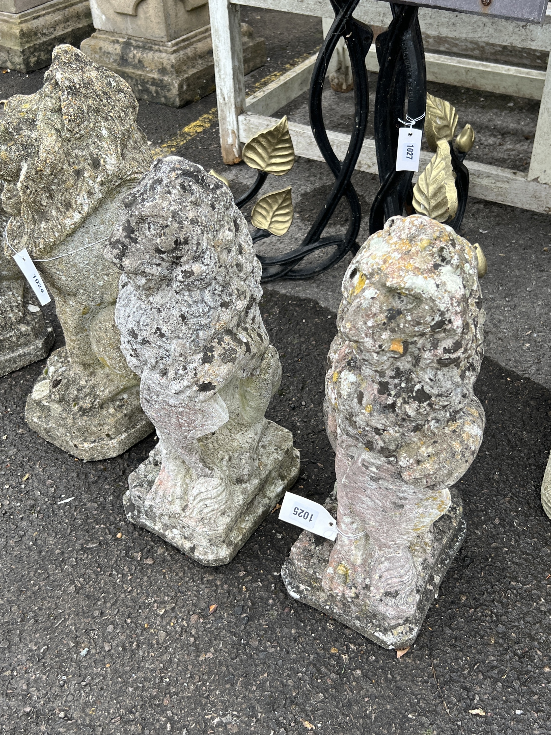 A pair of reconstituted stone heraldic lion garden ornaments, height 52cm